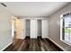 An open bedroom has wood floors, base trim, and white door at 2140 N Bay Hills Blvd, Safety Harbor, FL 34695