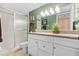 Well-lit bathroom with a glass shower, white cabinets, granite counters, and neutral tiles at 2756 Clubhouse Dr # 101, Sarasota, FL 34232