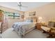 Comfortable bedroom with a ceiling fan, patterned bedding, and natural light from the window at 2756 Clubhouse Dr # 101, Sarasota, FL 34232