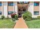 Building facade with manicured landscaping, a paved walkway, and an inviting entrance at 2756 Clubhouse Dr # 101, Sarasota, FL 34232