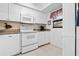 All-white kitchen featuring modern appliances, granite counters, and ample cabinet storage at 2756 Clubhouse Dr # 101, Sarasota, FL 34232