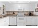 Well-lit kitchen with all-white appliances, granite countertops, and ample cabinet space at 2756 Clubhouse Dr # 101, Sarasota, FL 34232