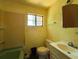 Bathroom featuring a green bathtub, white toilet and sink, and window at 655 36Th S Ave, St Petersburg, FL 33705