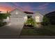 Beautiful one-story home with a garage and well-maintained landscaping at dusk at 12905 Satin Lily Dr, Riverview, FL 33579