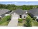 Aerial view of a single Gathering home, features a well-manicured lawn, gray stucco exterior, and black shingle roof at 12905 Satin Lily Dr, Riverview, FL 33579