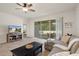 Bright living room features tile floors, neutral walls, and sliding door to patio at 12905 Satin Lily Dr, Riverview, FL 33579