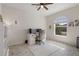Bright home office with a ceiling fan, wood-look tile floor, and a large window offering plenty of natural light at 12905 Satin Lily Dr, Riverview, FL 33579