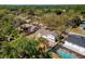 Aerial view of a cozy home with a fenced yard, lush trees, and a sparkling blue pool, perfect for outdoor living at 7105 N Whittier St, Tampa, FL 33617