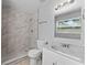 Bathroom featuring a walk-in shower with marble tile, white vanity, and updated fixtures at 7105 N Whittier St, Tampa, FL 33617