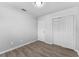 Bedroom featuring wood-look floors, a closet, and neutral wall paint at 7105 N Whittier St, Tampa, FL 33617