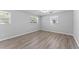 Bright bedroom featuring wood-look floors and natural light from three windows at 7105 N Whittier St, Tampa, FL 33617