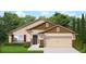 Inviting single-Gathering home with a two-car garage, lush lawn, and decorative stone accents at 13197 Gulf Bay Ln, Spring Hill, FL 34609