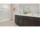 Bathroom featuring a double sink vanity, shower, neutral colors, and decor at 30948 Silver Stage Dr, Brooksville, FL 34602