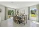 Dining room with a modern table set, neutral decor, and sliding glass doors leading to an outdoor area at 30948 Silver Stage Dr, Brooksville, FL 34602