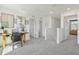 Bright hallway with desk space featuring neutral paint, artwork, and gray carpet at 30948 Silver Stage Dr, Brooksville, FL 34602