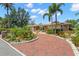 Inviting home featuring a brick driveway, lush landscaping, and beautiful curb appeal, complete with palm trees at 852 3Rd Ave S, Tierra Verde, FL 33715