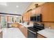 Well-equipped kitchen with black appliances, light wood cabinets and ample countertop space at 852 3Rd Ave S, Tierra Verde, FL 33715