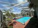 Gorgeous screened-in pool surrounded by lush tropical landscaping, creating a private backyard oasis at 852 3Rd Ave S, Tierra Verde, FL 33715