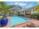 Private screened-in pool offers a refreshing escape with picturesque views of the canal and palm trees at 852 3Rd Ave S, Tierra Verde, FL 33715