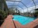 Stunning screened-in pool area with brick patio and beautiful water views, perfect for relaxation at 852 3Rd Ave S, Tierra Verde, FL 33715
