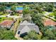 Aerial view of a home surrounded by trees, in a neighborhood near a scenic lake at 4318 River Birch Dr, Spring Hill, FL 34607