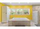 Bright yellow bathroom features tub, shower and storage at 4318 River Birch Dr, Spring Hill, FL 34607