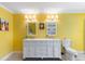 Yellow bathroom with dual sink vanity and matching mirror at 4318 River Birch Dr, Spring Hill, FL 34607