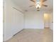 White bedroom with tile flooring, ceiling fan, and a double door closet at 4318 River Birch Dr, Spring Hill, FL 34607