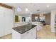 Open kitchen with white cabinets, stainless appliances, and a dark island with black countertops at 4318 River Birch Dr, Spring Hill, FL 34607
