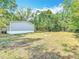 Expansive backyard with a designated fire pit area, surrounded by mature trees at 6008 Angus Valley Dr, Wesley Chapel, FL 33544