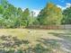 Large grassy backyard with a fire pit and a wooden fence creating a private outdoor space at 6008 Angus Valley Dr, Wesley Chapel, FL 33544