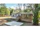 Inviting home with a wooden porch, concrete slab, complemented by a beautiful lawn and lush greenery at 6008 Angus Valley Dr, Wesley Chapel, FL 33544
