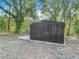 Durable metal shed on a concrete foundation, surrounded by trees and natural foliage at 6008 Angus Valley Dr, Wesley Chapel, FL 33544