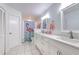 Bright bathroom with white tile, double sinks, white cabinets, and shower tub combo at 7102 Silvermill Dr, Tampa, FL 33635