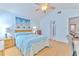 Bright bedroom with blue walls features a ceiling fan and access to the living area at 7102 Silvermill Dr, Tampa, FL 33635