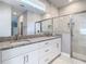Modern bathroom featuring double vanity with granite countertop and walk-in shower at 1696 Bendix Ter, North Port, FL 34286