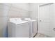 Modern laundry room featuring a white washer and dryer and shelving unit at 1696 Bendix Ter, North Port, FL 34286