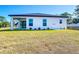 New home features a bright white exterior, covered patio, and spacious backyard with a beautiful lawn at 2223 Hattie Ct, North Port, FL 34288