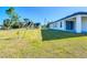 Backyard view of a new construction home with a large green lawn at 2223 Hattie Ct, North Port, FL 34288