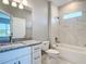 Bright bathroom featuring granite counters, white cabinets, and a tiled shower over tub at 2223 Hattie Ct, North Port, FL 34288
