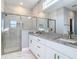 Modern bathroom featuring double sinks with granite countertops and a glass enclosed shower at 2223 Hattie Ct, North Port, FL 34288