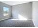 A gray bedroom with neutral carpet features a large window providing natural light at 2223 Hattie Ct, North Port, FL 34288