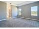 Well-lit primary bedroom featuring gray walls, plush carpet, and large windows at 2223 Hattie Ct, North Port, FL 34288