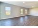 A bright living room with gray wood floors and three large windows offering natural light at 2223 Hattie Ct, North Port, FL 34288