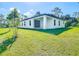 Spacious backyard with lush green lawn, complemented by a modern home exterior and mature trees at 2423 Sadnet Ln, North Port, FL 34286