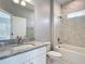 Bright bathroom featuring granite countertops, modern fixtures, and a marble-tiled shower and bathtub combo at 2423 Sadnet Ln, North Port, FL 34286