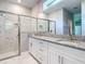 Bathroom featuring double vanities, granite countertops, and a glass-enclosed shower with marble tile at 2423 Sadnet Ln, North Port, FL 34286