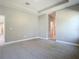 Spacious bedroom featuring neutral tones, carpet flooring, and a tray ceiling at 2423 Sadnet Ln, North Port, FL 34286