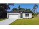Charming single-Gathering home with well-manicured lawn, attached garage, and a lovely light-blue front door at 2423 Sadnet Ln, North Port, FL 34286