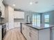 Modern kitchen with white cabinets, stainless steel appliances, granite countertops, and a large center island at 2423 Sadnet Ln, North Port, FL 34286